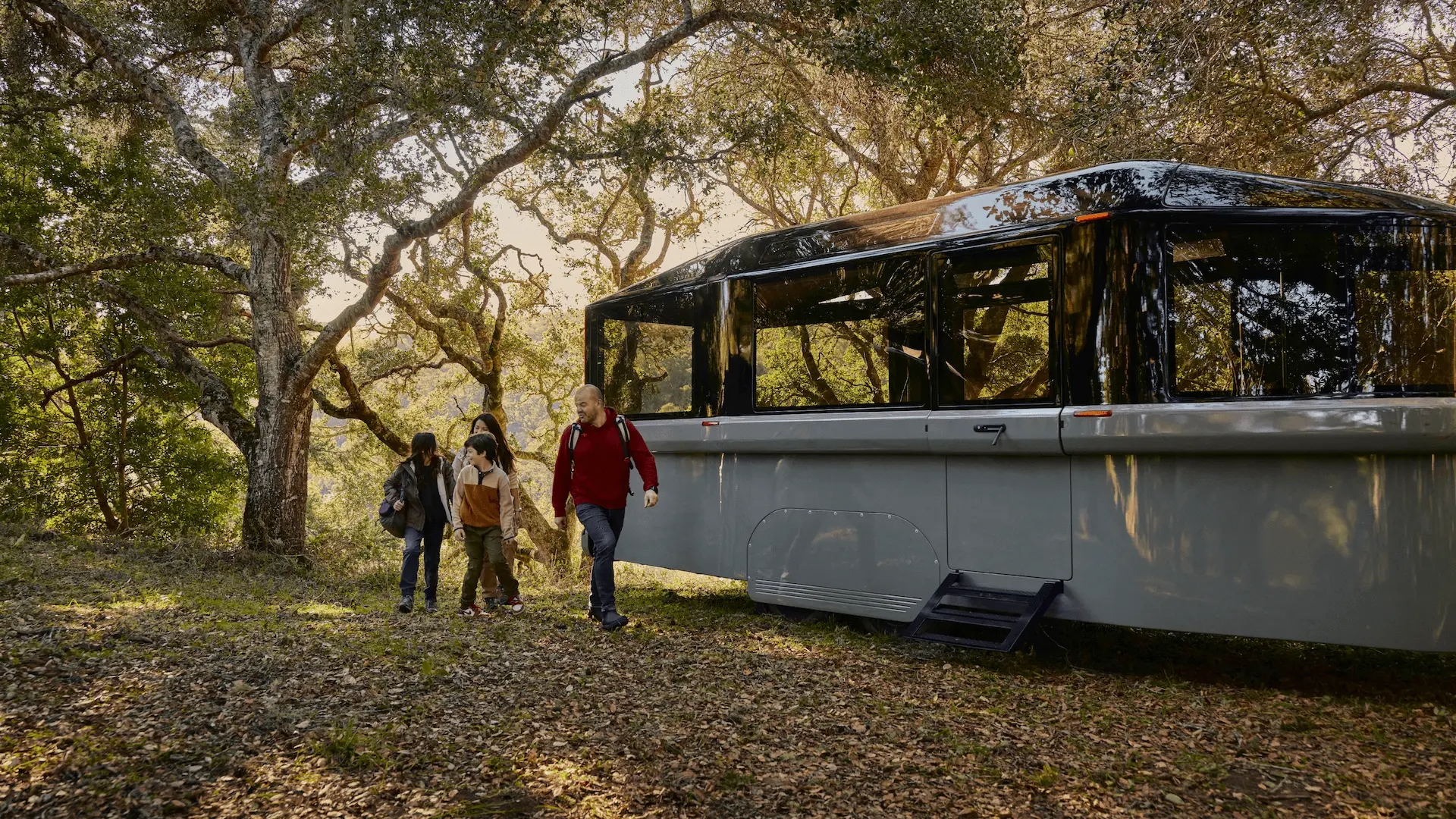 A family exits a modern Lightship RV parked in a wooded area.