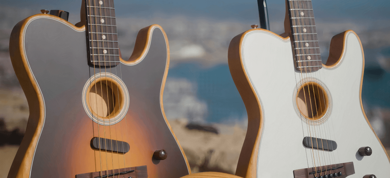 Two acoustic guitars by Fender with different finishes (one sunburst and one white) are positioned side by side outdoors with a blurred cityscape and waterway in the background.