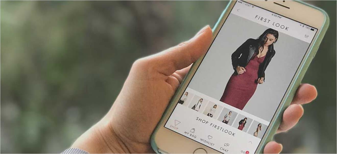 Person holding a smartphone displaying the GUESS jeans app with a woman modeling a red dress and black jacket on the screen, showcasing a perfect case study of modern mobile shopping experiences.