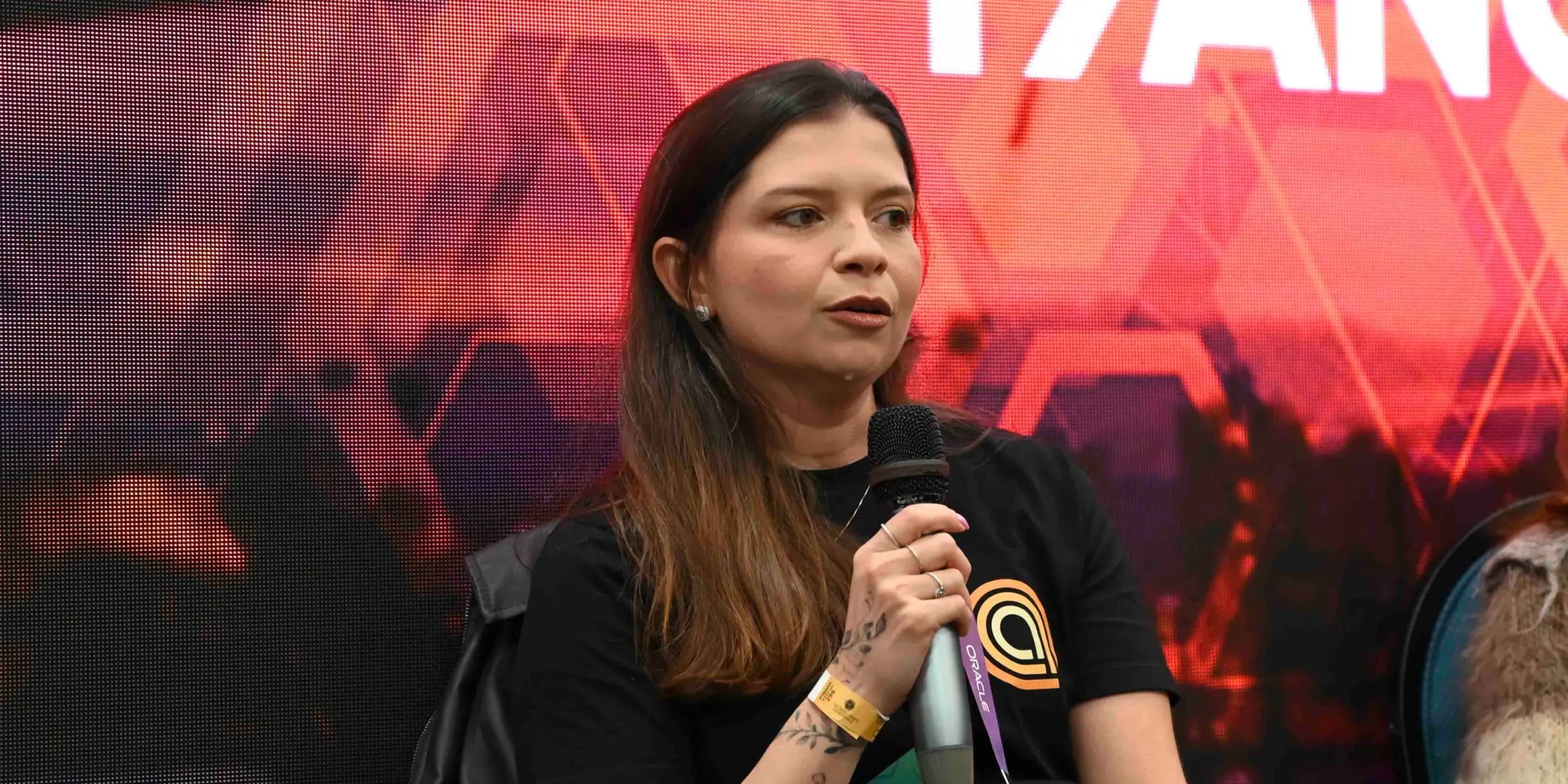 Sabrina speaking at a tech conference, wearing an ArcTouch shirt