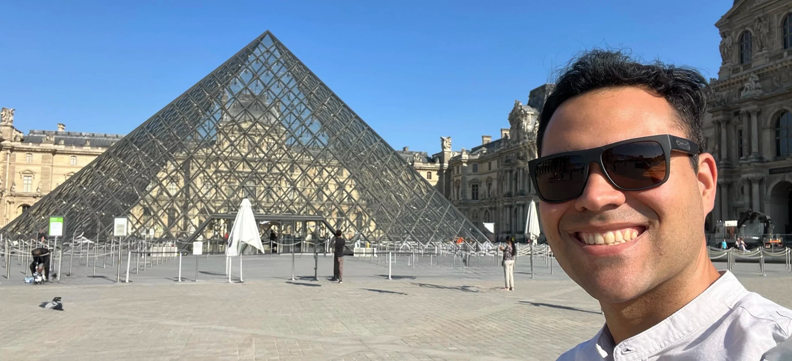 Picture of Fernando Rabello standing in front of the Louvre Museum in Paris