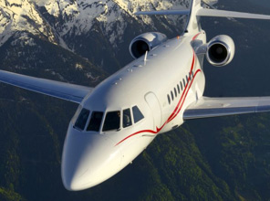 Private jet flying with snow covered mountain peaks in the background